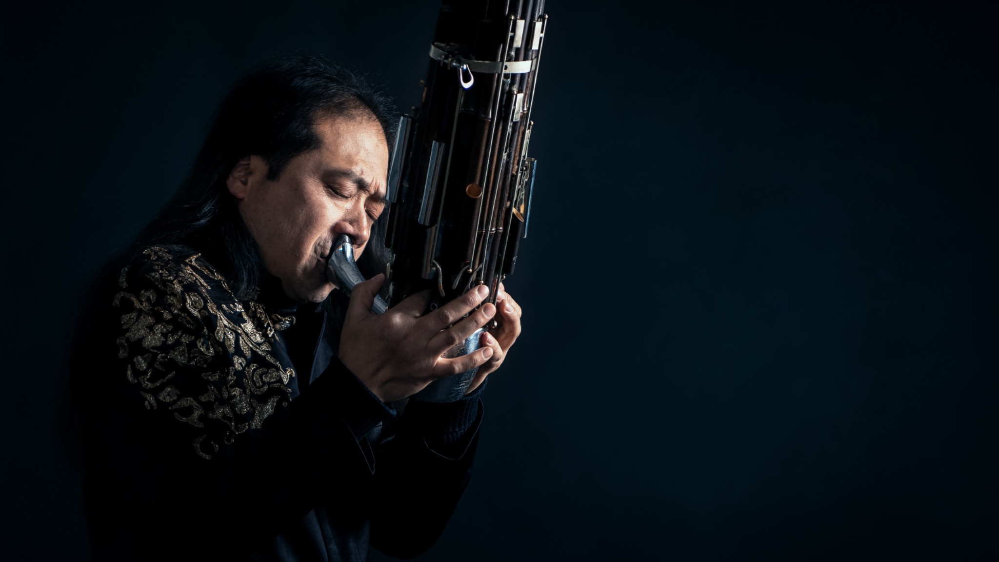 Wu Wei playing the sheng in a dramatic portrait